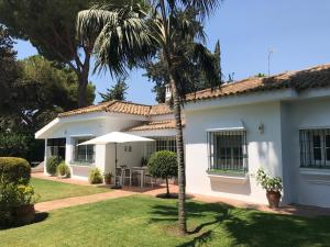 ein Haus mit einer Palme davor in der Unterkunft La Huerta Pintada in El Puerto de Santa María