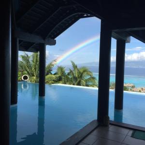 a rainbow over a swimming pool with a rainbow at Villa BellaVista in Teavaro
