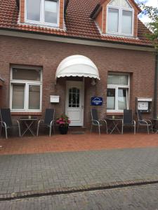 a brick house with chairs and an awning at Ferienhaus Zunftstuben in Norderney