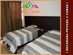 two beds in a hotel room with a sign on the wall at Departamentos & Suites Villa Teresa in Ciudad Victoria