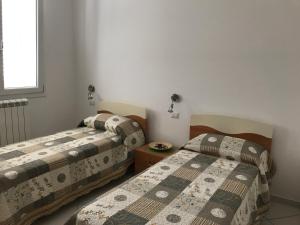 パエストゥムにあるCasa Vacanze Villa Italia Paestumのベッド2台が隣同士に設置された部屋です。
