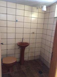 une salle de bains avec toilettes et lavabo dans l'établissement Pousada e Restaurante do Porto, à São João Batista do Glória