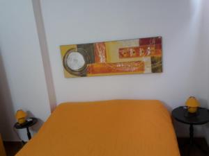 una camera da letto con un letto e un dipinto sul muro di Palazzo Graziano a Terrasini