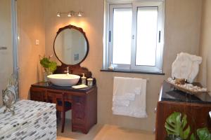 a bathroom with a sink and a mirror at Cantinho da Bela Vista in Porto Judeu +44 photos