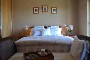 a bedroom with a large bed with a table and chairs at Cantinho da Bela Vista in Porto Judeu