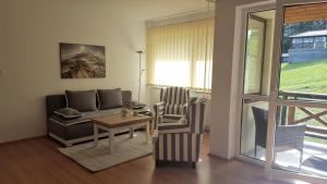 ein Wohnzimmer mit einem Sofa und einem Tisch in der Unterkunft Pinewood Valley Oasis in Vyšné Ružbachy