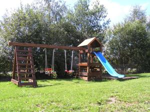 a wooden playground with a slide and a slide at Apartmány holiday Frymburk in Frymburk