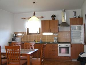 eine Küche mit einem Tisch, Stühlen und einem Tisch sowie eine Küche mit einem Herd in der Unterkunft Apartmány holiday Frymburk in Frymburk