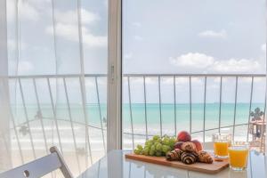- une assiette de fruits sur une table avec vue sur la plage dans l'établissement Dream On the Beach, à Haïfa