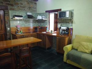 a kitchen with a counter and a table and a couch at Apartamentos Rurales Casa Cachon in Santa Eulalia de Cueras +25 photos