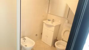 a white bathroom with a toilet and a sink at Appartamento Giulia in Moneglia +15 photos