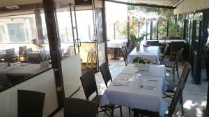 a restaurant with white tables and chairs and windows at Appartamento Giulia in Moneglia