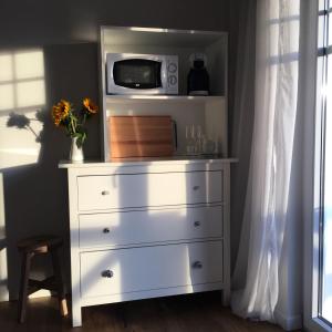 a white dresser with a microwave on top of it at Zimmer mit Bad und Balkon in Widen +16 photos