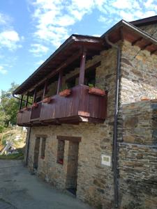 a building with a balcony on the side of it at Apartamentos Rurales Casa Cachon in Santa Eulalia de Cueras