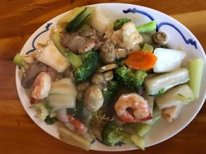 un plato de comida con camarones y verduras en una mesa en Glacier View Inn, en Haines Junction