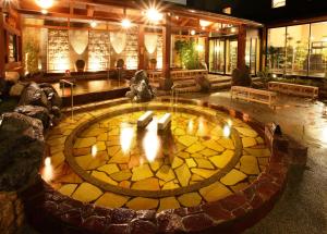 a lobby with a fire pit in the middle of a building at Sakaihama Rakuten Onsen Shofuku in Sakai