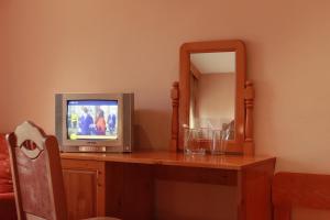 une télévision assise sur une table en bois avec un miroir dans l'établissement Guest House Tabakovi, à Velingrad