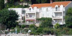 uma grande casa branca com um telhado laranja em Dubrovnik Apartments em Dubrovnik
