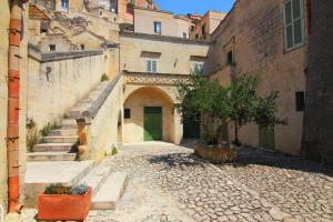 an alley in an old building with stairs and a door at Piano Piano - Rooms in Matera