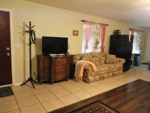 a living room with a couch and a flat screen tv at Charming Downstairs Unit in Oakhurst