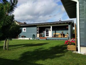a house with a patio and a yard at Kontininku Namelis in Palanga