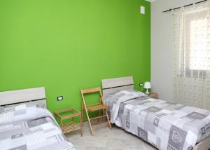 a green bedroom with two beds and two chairs at B&B Masseria Cozzi in Lauria Inferiore