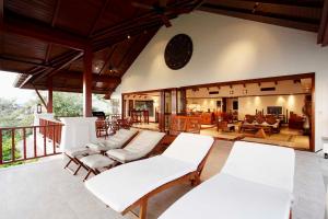 - un salon avec des meubles blancs sur une terrasse couverte dans l'établissement Villa Suriya B2, à Patong Beach