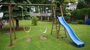 a playground with two swings and a slide at Hotel Restaurant Stöckl in Bad Deutsch Altenburg
