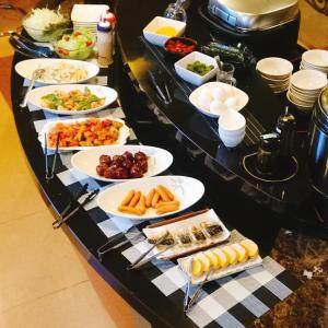 a buffet with plates of food on a table at Hotel Satellite in Satsumasendai