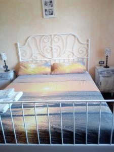 a bed with a white headboard and two night stands at Terramadre in Itri