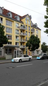 un coche blanco estacionado frente a un edificio amarillo en Schwalbennest, en Fürth