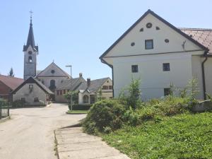 un gran edificio blanco con una iglesia al fondo en Apartments Avio, en Zgornji Brnjik