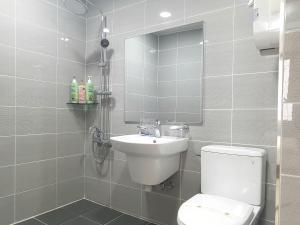een badkamer met een toilet, een wastafel en een spiegel bij VIP Hotel Mokpo in Mokpo
