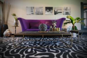 a living room with a purple couch and a table at SeeHotel & Restaurant die Ente in Schwetzingen