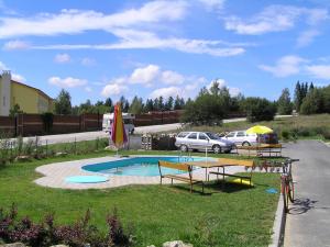 einen Pool mit einem Tisch und einem Sonnenschirm in einem Hof in der Unterkunft Apartmány holiday Frymburk in Frymburk
