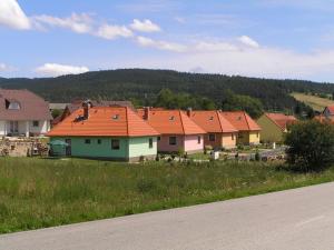 eine Gruppe von Häusern mit orangefarbenen Dächern auf einem Feld in der Unterkunft Apartmány holiday Frymburk in Frymburk