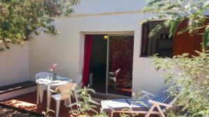 une terrasse avec une table et des chaises devant une maison dans l'établissement Casa Orsoni, à Calvi