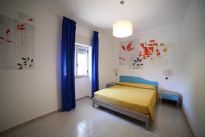 トッレ・ヴァードにあるHotel Albatrosのベッドルーム(黄色のベッド1台、青いカーテン付)