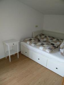 ein Schlafzimmer mit einem Bett und einem kleinen Tisch in der Unterkunft Ferienhaus Förster III in Thale