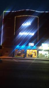 a building with blue lights on the side of it at Avene For Furnished Residential Units in Ad Dawādimī