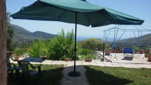 a green umbrella on a patio with chairs and tables at Terramadre in Itri