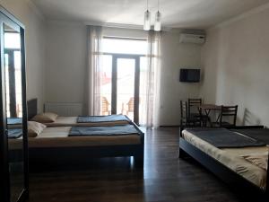 una camera da letto con due letti, un tavolo e delle sedie di Hotel Sunny Coast a Kobuleti