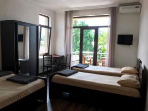 una stanza con tre letti e una finestra di Hotel Sunny Coast a Kobuleti