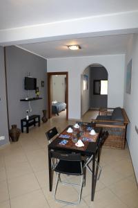 a dining room and living room with a table and chairs at Conte Agostino Pepoli in Trapani