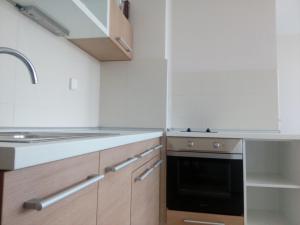 a kitchen with white cabinets and a sink at City Center Apartment in Valjevo