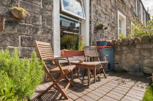 twee stoelen en een tafel op een patio bij Cozy with Character Vibrant Cottage Style Flat at Leith Links Park in Edinburgh