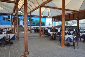 un ristorante con tavoli e sedie in un edificio di Settebello Village a Lido Di Fondi