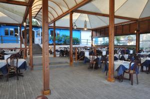 ein Restaurant mit Tischen und Stühlen in einem Gebäude in der Unterkunft Settebello Village in Lido Di Fondi