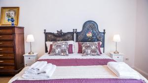 1 dormitorio con 1 cama grande con almohadas rosas y blancas en Siqillya Etna, en Linguaglossa