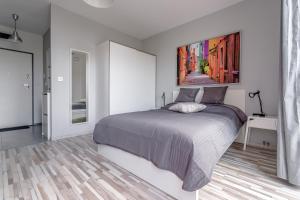 a bedroom with a bed and a painting on the wall at Chill Apartments Wola Center in Warsaw